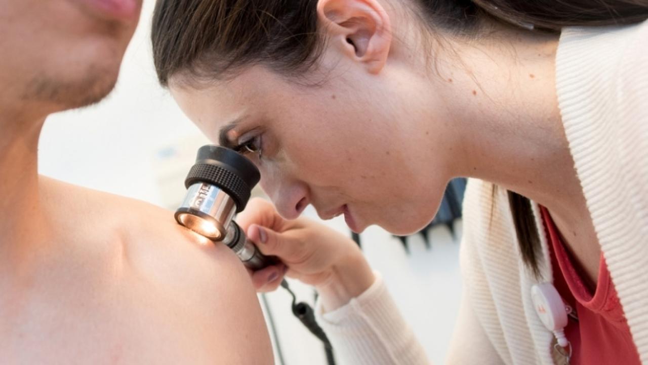 Elizabeth Marchionne, MD, examines a mole on a patient's shoulder. Credit: Barbara Ries