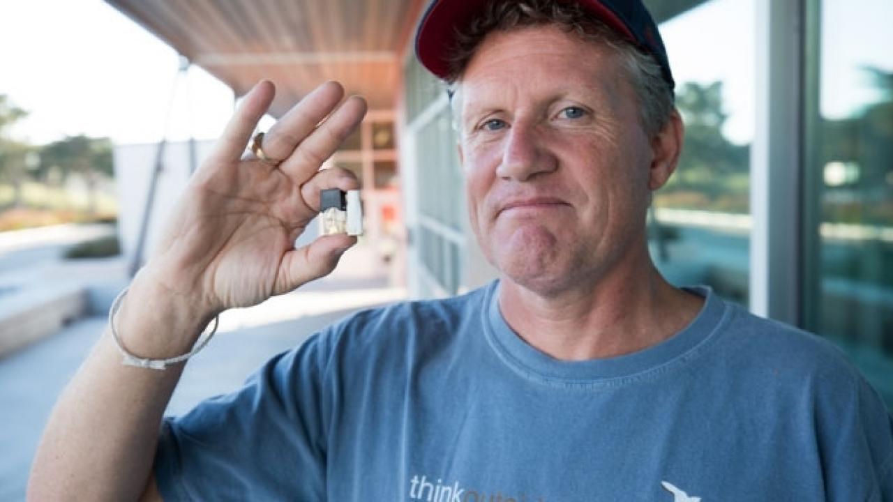 UCSF associate professor Jeremiah Mock holding a JUUL e-cigarette cartridge and a cigarette butt he found on a local high school campus (photo by Elisabeth Fall)