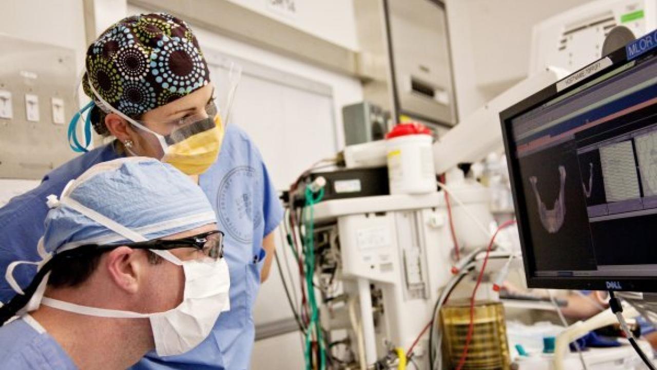 Jason Pomerantz, MD, and Carrie McCloskey, MD, repair a patient's jaw bone at UCSF Medical Center. Photo by Susan Merrell