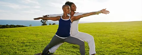 two women doing yoga outdoors