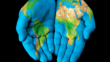 Hands painted with the global map, indicating cooperation across the world