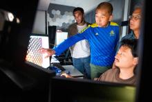 UCSF professor Yifan Cheng, PhD (center), gestures while examining a Cryo-EM sample along with associate researcher Rob Seed, PhD (left), postdoctoral scholar Mingliang Jin, PhD (bottom right), and professor Stephen Nishimura, PhD (right). Photo by Noah Berger