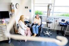 Colorectal cancer patient Megan McNair speaks with oncologist Katherine Van Loon, MD (left), while receiving an infusion at UCSF. Photo by Noah Berger