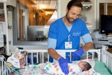 Ryan Grant, RN, a clinical nurse in the Pediatric Intensive Care Nursery, checks on his 15-day-old patient at UCSF Benioff Children’s Hospital, San Francisco. Photo by Susan Merrell 