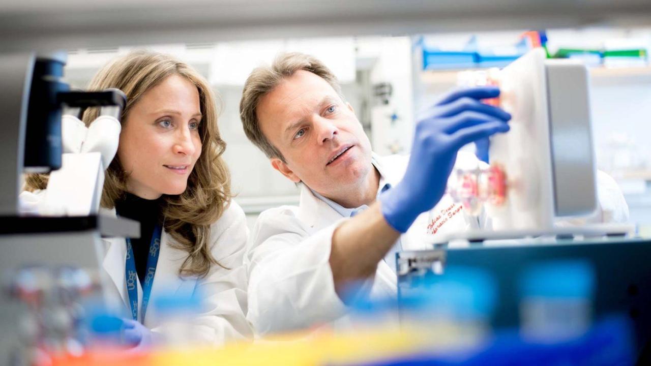Tobias Deuse holds up an instrument in his lab