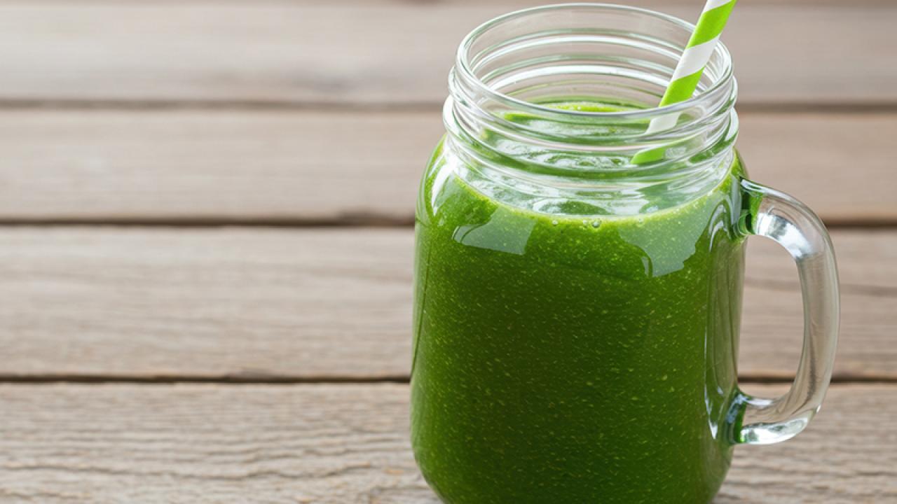 green smoothie in jar with straw