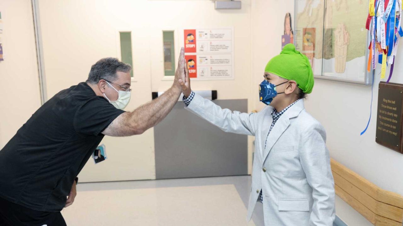 A young male patient named Manwar high fives a nurse at Benioff Children's Hospital Oakland.