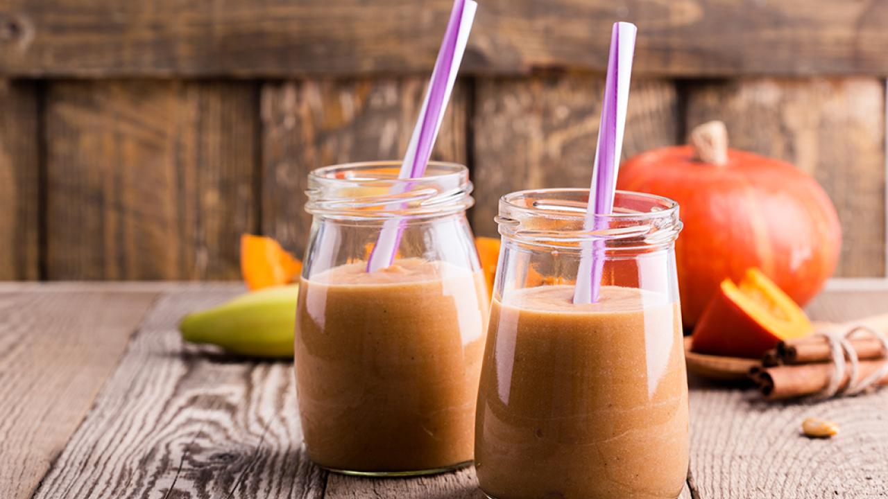 two pumpkin banana smoothies in glasses with straws