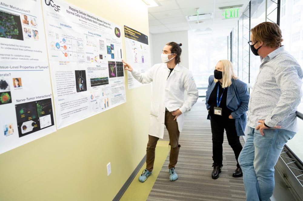 Martin Žídek, MD, far left, postdoctoral fellow, explains his cancer research to his PI Valerie Weaver, PhD, professor of Surgery, and Jeroen Roose, PhD, professor of Anatomy and director of a collaborative research grant from the Mark Foundation to study metastatic cancer