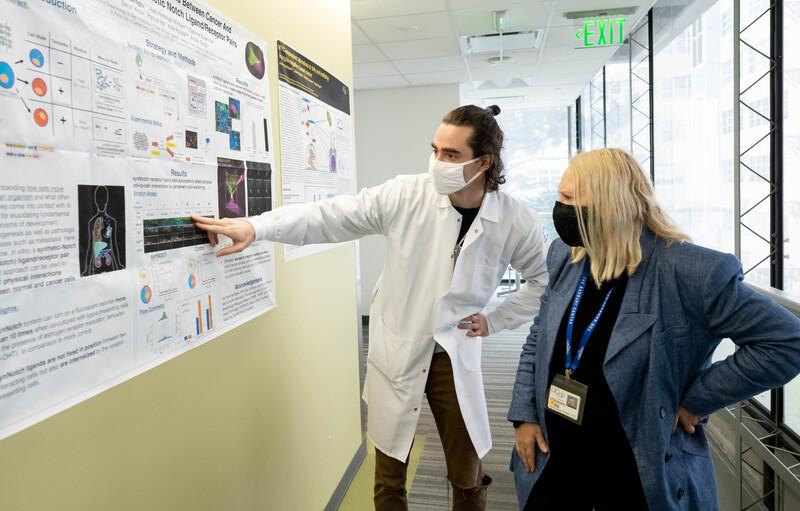 Val Weaver reviews scientific poster at UCSF.