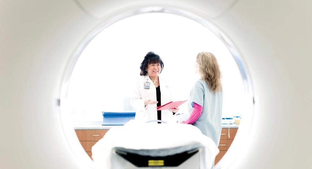 Judy Yee with a patient at an MRI machine