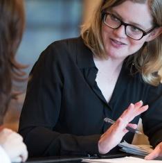 Woman with paperwork explaining to another woman