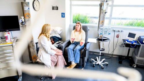 Colorectal cancer patient Megan McNair speaks with oncologist Katherine Van Loon, MD (left), while receiving an infusion at UCSF. Photo by Noah Berger