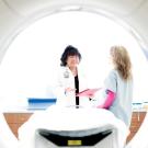 Judy Yee leads a patient to an MRI machine