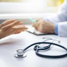 image showing hands of patient and doctor as they have a discussion across a desk