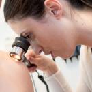 Elizabeth Marchionne, MD, examines a mole on a patient's shoulder. Credit: Barbara Ries