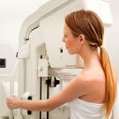 Woman leaning into breast mammography machine